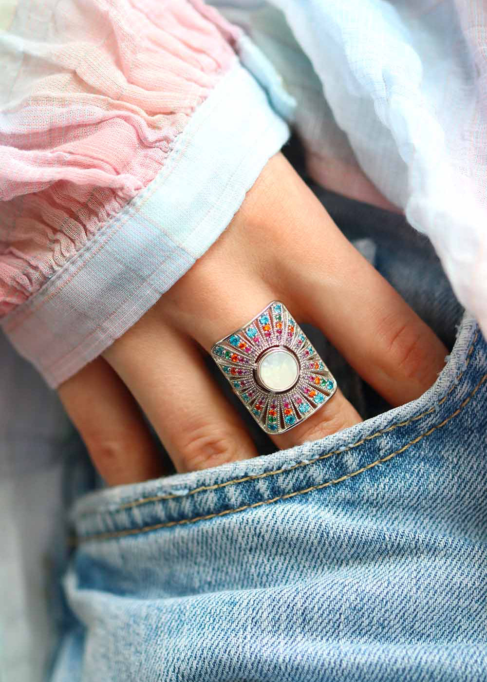 Bague femme en argent avec une nacre ronde centrale et un effet rayonnant multicolore